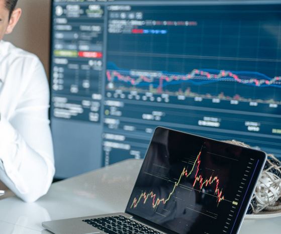 SEO Agentur Augsburg. Ein Mann sitzt vor Analyse Monitoren, die SEO Statistiken zeigen.